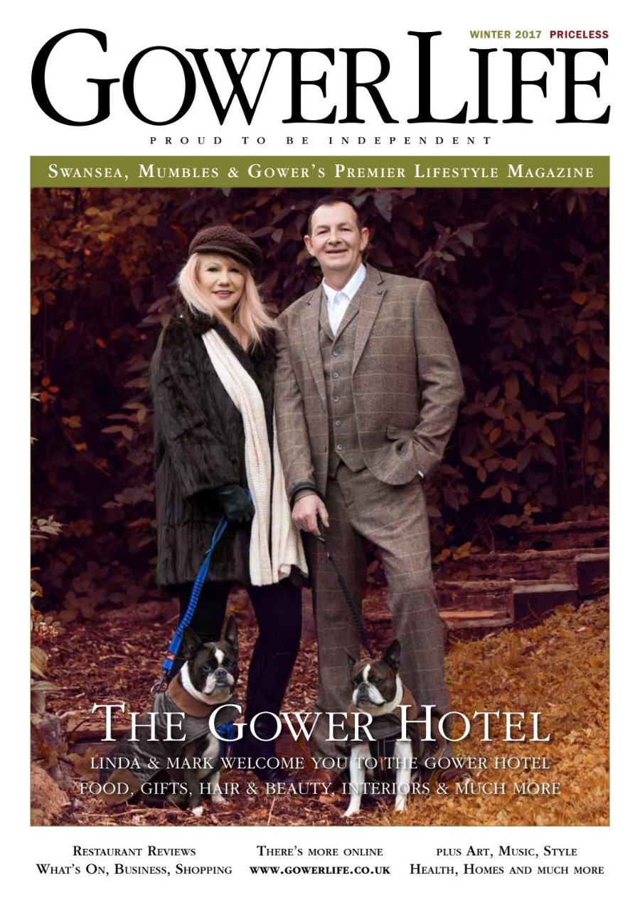 Gower Life Winter 2017 cover. Linda Clayton-Evans, with long blonde hair, a brown hat, a dark coat and a cream scarf, stands beside Mark Clayton-Evans in a brown tweed three-piece suit, each holding a black and white dog on a lead, against a backdrop of copper autumn leaves. Headline: The Gower Hotel.